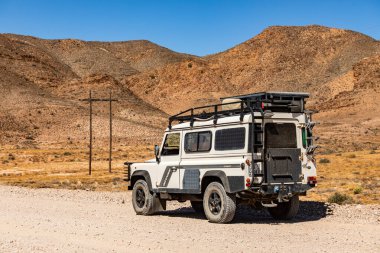 Namaqualand, Güney Afrika - 11 Mart 2024: Eski Land Rover Defender kurak bölgede bir çakıl yoluna park etti