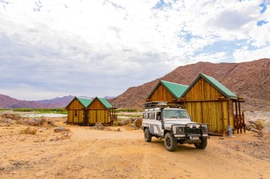 Richtersveld, South Africa - March 12, 2024: Old Land Rover Defender parked at a campsite in arid region clipart