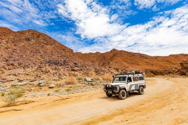 Richtersveld, Güney Afrika - 12 Mart 2024: Eski Land Rover Defender kurak bölgede bir çakıl yoluna park etti