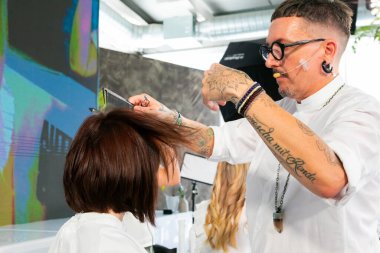 Cape Town, Güney Afrika - 15 Kasım 2022: Kuaförde genç bayan modeller üzerinde çalışan profesyonel stilist