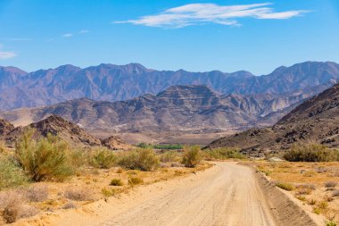 Richtersveld Ulusal Parkı 'ndaki çakıllı toprak yol, Güney Afrika' nın çorak bölgesi.