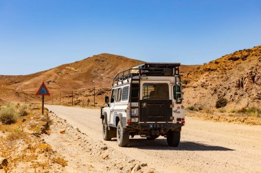 Namaqualand, Güney Afrika - 11 Mart 2024: Eski Land Rover Defender kurak bölgede bir çakıl yoluna park etti