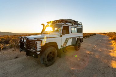 Namaqualand, Güney Afrika - 9 Mart 2024: Eski Land Rover Defender kurak bölgede bir çakıl yoluna park etti