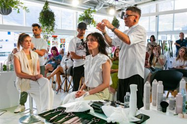 Cape Town, Güney Afrika - 15 Kasım 2022: Kuaförde genç kadın modelle gösteri yapan profesyonel stilist