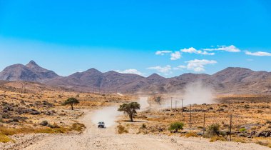 4x4 araç Güney Afrika 'daki Richtersveld Ulusal Parkı' nda çakıl yolda ilerliyor.