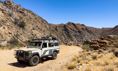 AUGRABIES, Güney Afrika - 16 Kasım 2024: Eski Land Rover Defender toprak yola park etti