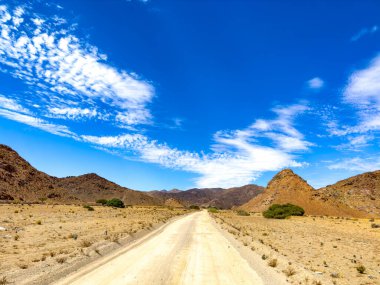 Richtersveld Ulusal Parkı 'ndaki çakıllı toprak yol, Güney Afrika' nın çorak bölgesi.