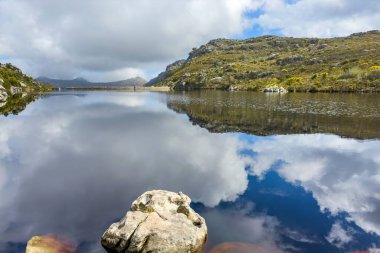 Cape Town engebeli dağlarının tepesindeki rezervuar barajının manzarası