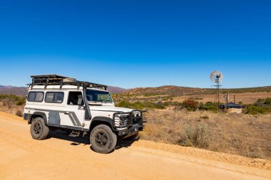 Namaqualand, Güney Afrika - 9 Mart 2024: Eski Land Rover Defender kurak bölgede bir çakıl yoluna park etti