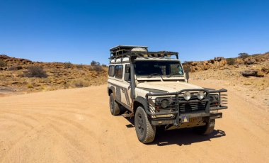 AUGRABIES, Güney Afrika - 16 Kasım 2024: Eski Land Rover Defender toprak yola park etti