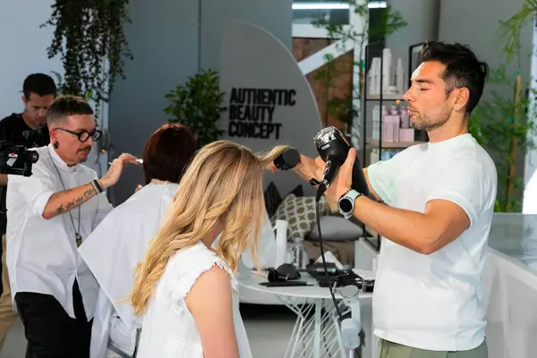 Cape Town, Güney Afrika - 15 Kasım 2022: Kuaförde genç kadın modelle gösteri yapan profesyonel stilist