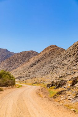 Richtersveld Ulusal Parkı 'ndaki çakıllı toprak yol, Güney Afrika' nın çorak bölgesi.