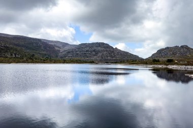 Cape Town engebeli dağlarının tepesindeki rezervuar barajının manzarası