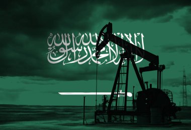 Gün batımında Suudi Arabistan ulusal bayrağıyla kırsal kesimde petrol arama çalışması