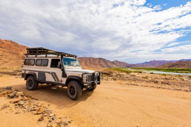 Richtersveld, Güney Afrika - 12 Mart 2024: Eski Land Rover Defender kurak bölgede bir çakıl yoluna park etti