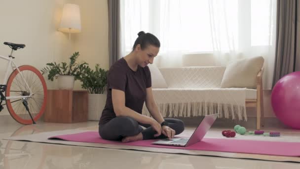 Woman Sitting Exercise Mat Living Room Using Laptop While Looking — Vídeos de Stock
