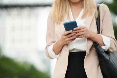 Cropped image of businesswoman checking messages in her smartphone