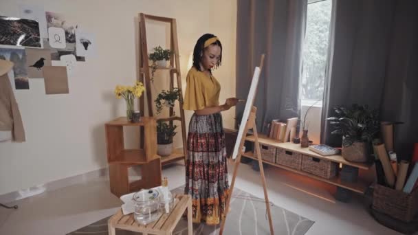Young African American Woman Standing Living Room Painting Picture Canvas — Stockvideo