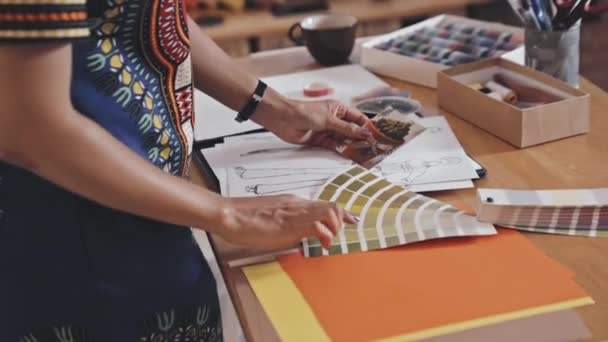 非洲裔美国女设计师手握植物照片 与绿色托盘一起在缝纫车间桌上工作的特写镜头 — 图库视频影像