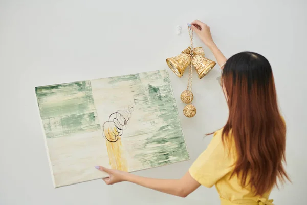Young Woman Hanging Golden Bells Abstract Picture Wall Apartment View — Stock fotografie