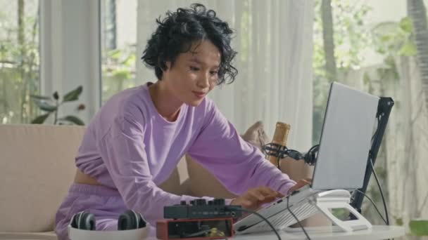 Medium Shot Asian Gen Girl Typing Laptop While Creating Audio — Stock Video