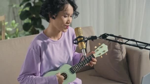 Asian Gen Girl Playing Ukulele Singing Mic Using Laptop Midi — стоковое видео