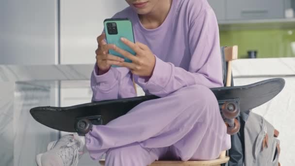 Tilt Shot Asian Gen Girl Wearing Headphones Sitting Home Skateboard — Stockvideo