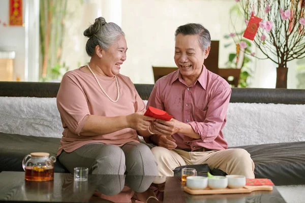 Smiling Senior Couple Exchaning Chinese New Year Gifts — Fotografia de Stock