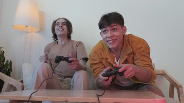 Two Cheerful Boys Early 20S Having Fun Home Playing Video — стоковое видео