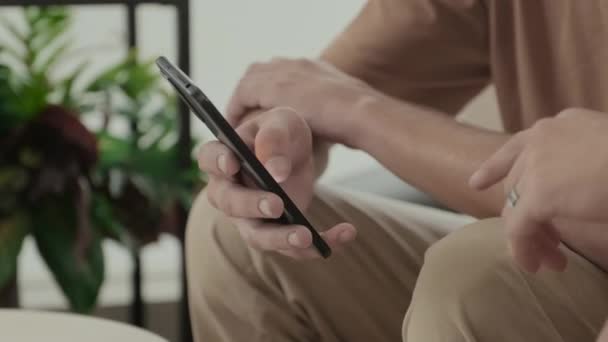Two Unrecognizable Male Friends Scrolling Smartphone While Staying Home Together — Vídeo de stock