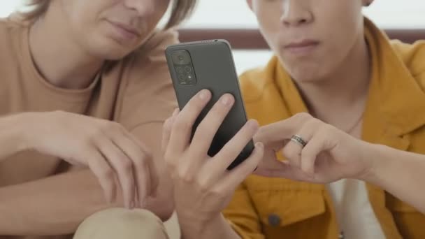 Two Buddies Early 20S Scrolling Feed Smartphone Having Discussion While — Stock video