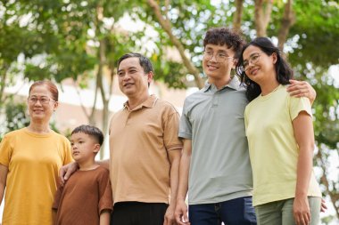 Happy family of three generation standing in city park