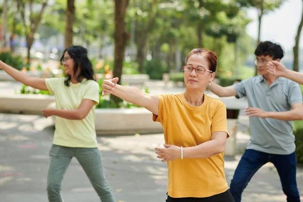 Senior Woman Exercising Outdoors Her Family —  Fotos de Stock