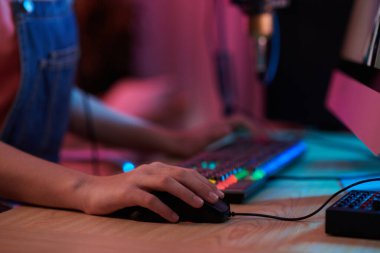 Closeup image of teenage girl playing strategy game on computer late at night