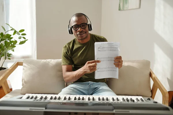 Happy proud man showing music notes for song he wrote