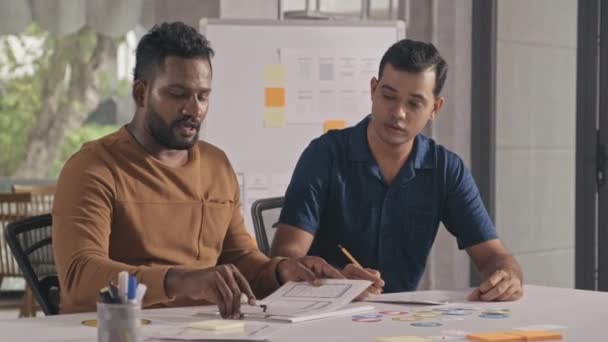 Medium Shot Two Indian Coworkers Discussing Sketches While Developing Project — Vídeo de Stock