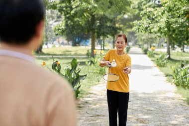 Senior woman playing badminton with her husband