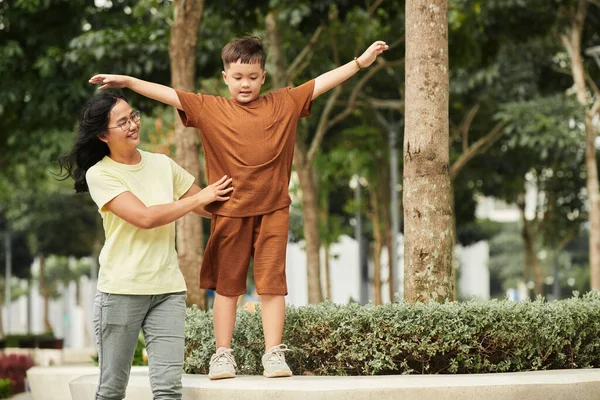 Mother Supporting Preteen Son Walking Flowerbed — 스톡 사진