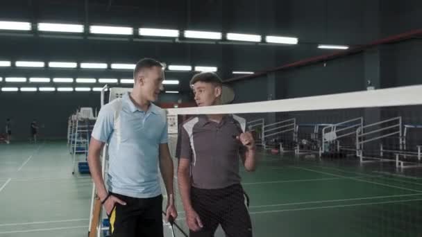 Two Sportsmen Walking Rackets Net Indoor Court Speaking Giving Fist — Videoclip de stoc