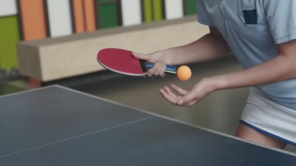 身着运动服的女子拿着球拍抛掷乒乓球准备打乒乓球时被剪下来的照片 — 图库视频影像