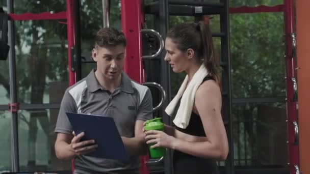 Young Fit Woman Sportswear Standing Water Towel Discussing Workout Program — Wideo stockowe