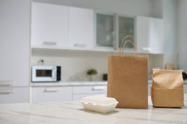 Packages with food delivered from local cafe on kitchen counter