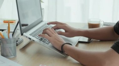 Masadaki dizüstü bilgisayarlarda yazan tanınmayan erkek ofis çalışanlarının yakın çekim görüntüleri.