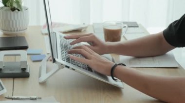Ofis masasında dizüstü bilgisayarda çalışan tanınmayan bir erkek mimarın yakın çekimleri.