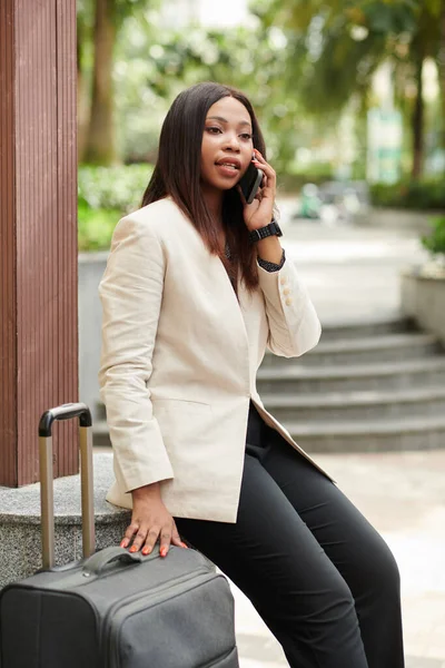 Portrait Serious Businesswoman Sitting Outdoors Next Suitcases Talking Phone Assistant — Stok fotoğraf