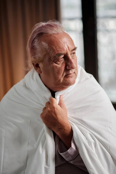 Πορτραίτο Του Παγωμένου Ηλικιωμένου Άνδρα Που Τυλίγεται Πάπλωμα Και Κοιτάζει — Φωτογραφία Αρχείου