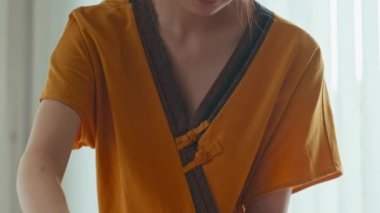 Tilt down shot of young Asian masseuse doing back massage for woman visiting luxury spa salon