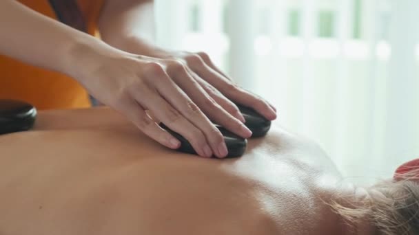 Closeup Unrecognizable Masseuse Doing Stone Massage Female Client Luxury Spa — Wideo stockowe