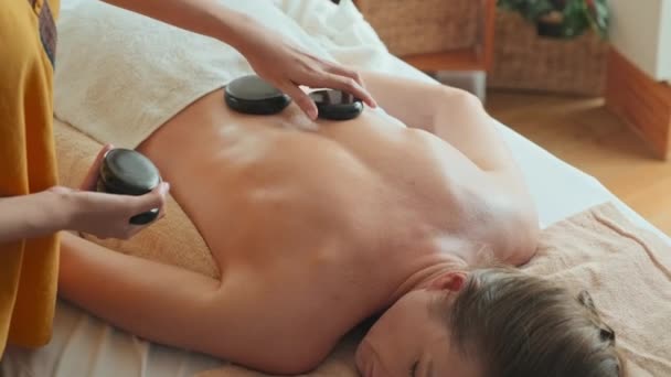 Onherkenbare Vrouwelijke Klant Met Professionele Hot Stone Massage Luxe Spa — Stockvideo