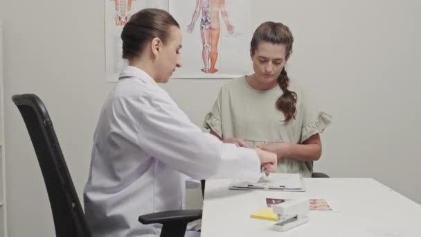在与诊所女医生会诊期间签署医疗协议的孕妇 — 图库视频影像